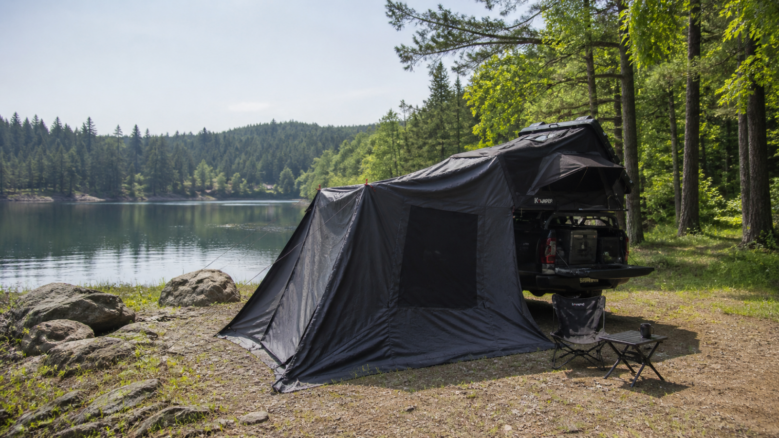 Overland truck with rooftop tent and awning set up beside a Canadian lake in early summer, ready for backcountry camping and vehicle maintenance prep